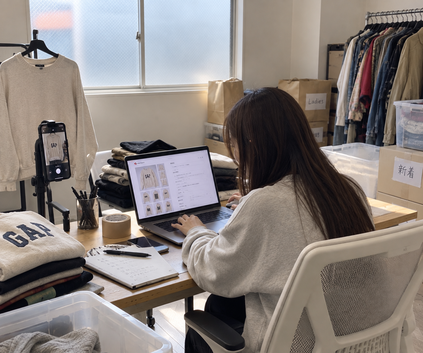 GLOW WORKS 生野で、衣類の撮影とパソコンによる商品登録に取り組んでいる実際の作業風景。
